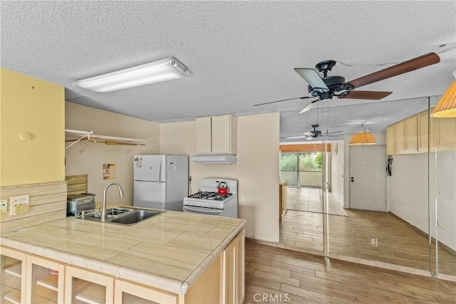 15321 Santa Gertrudes Ave Unit J210, La Mirada, CA 90638 - kitchen featuring white appliances, under cabinet range hood, tile counters, ceiling fan, and a peninsula