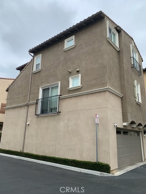 22111 Main St Unit 6, Carson, CA 90745 - view of side of home with stucco siding and a garage