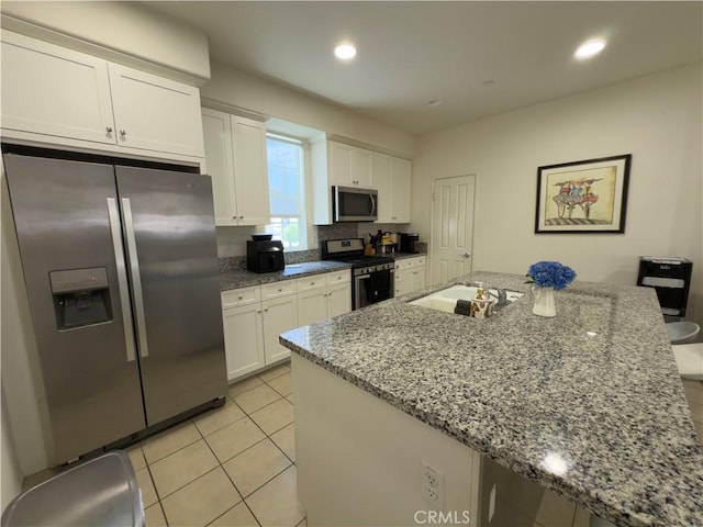 22111 Main St Unit 6, Carson, CA 90745 - kitchen featuring stainless steel appliances, white cabinets, light tile patterned flooring, light stone countertops, and recessed lighting