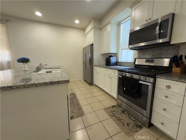 22111 Main St Unit 6, Carson, CA 90745 - kitchen with appliances with stainless steel finishes, white cabinetry, light tile patterned flooring, light stone counters, and recessed lighting