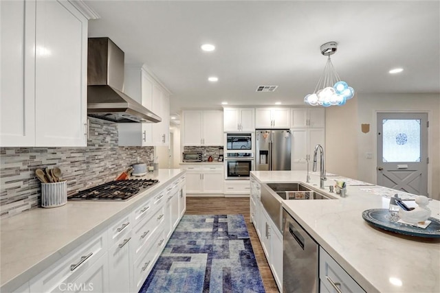 12081 Martha Ann Dr, Los Alamitos, CA 90720 - kitchen with wall chimney exhaust hood, stainless steel appliances, a sink, white cabinetry, and recessed lighting