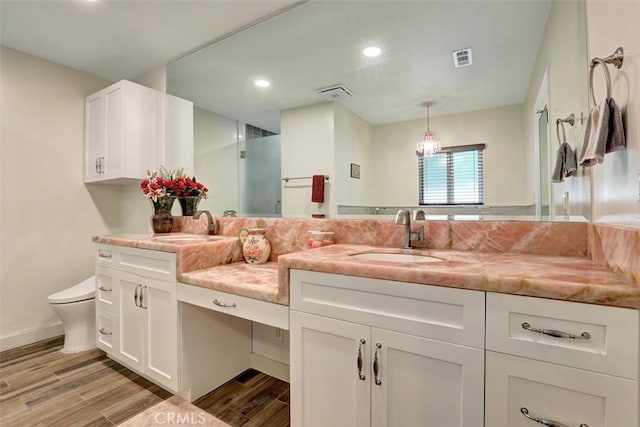 12081 Martha Ann Dr, Los Alamitos, CA 90720 - full bath featuring double vanity, wood finished floors, toilet, a shower with shower door, and recessed lighting