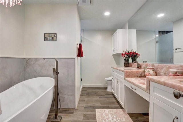 12081 Martha Ann Dr, Los Alamitos, CA 90720 - full bath featuring vanity, wood finished floors, a soaking tub, recessed lighting, and toilet
