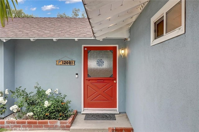 12081 Martha Ann Dr, Los Alamitos, CA 90720 - doorway to property with roof with shingles and stucco siding