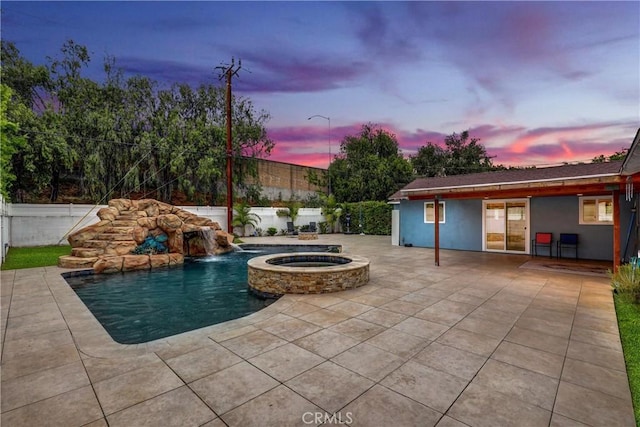 12081 Martha Ann Dr, Los Alamitos, CA 90720 - pool at dusk with a patio, a fenced backyard, and a pool with connected hot tub