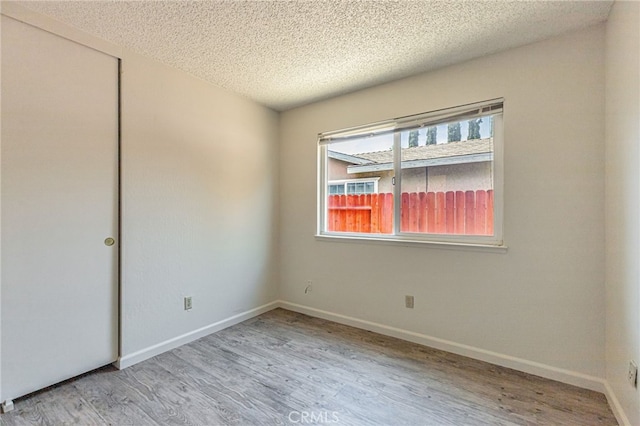 5712 Tupelo Dr, Sacramento, CA 95842 - spare room with a textured ceiling, wood finished floors, and baseboards
