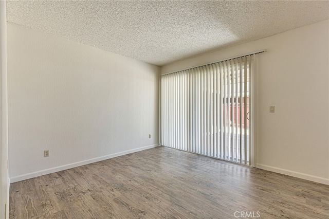 5712 Tupelo Dr, Sacramento, CA 95842 - empty room with a textured ceiling, wood finished floors, and baseboards