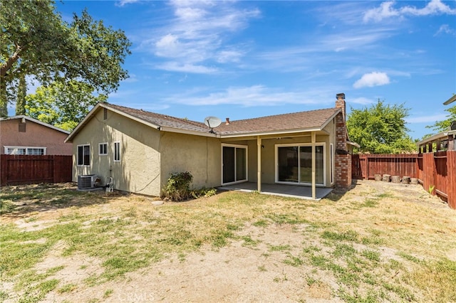 5712 Tupelo Dr, Sacramento, CA 95842 - back of house with central air condition unit, a patio, a chimney, and stucco siding