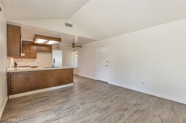 5712 Tupelo Dr, Sacramento, CA 95842 - kitchen with a sink, open floor plan, a peninsula, a ceiling fan, and wood finished floors