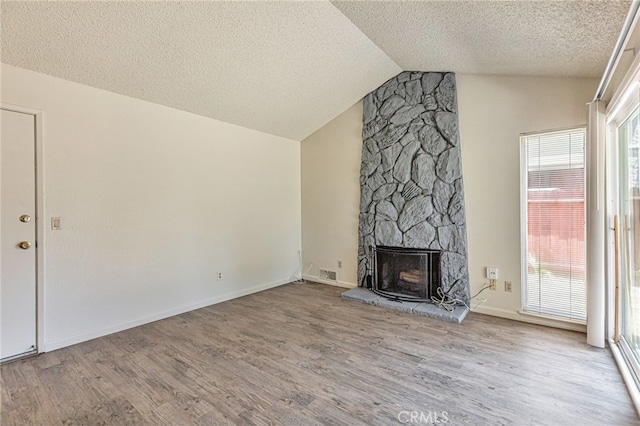 5712 Tupelo Dr, Sacramento, CA 95842 - unfurnished living room with a textured ceiling, wood finished floors, vaulted ceiling, and a fireplace