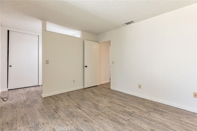 5712 Tupelo Dr, Sacramento, CA 95842 - unfurnished bedroom with wood finished floors, a textured ceiling, and baseboards