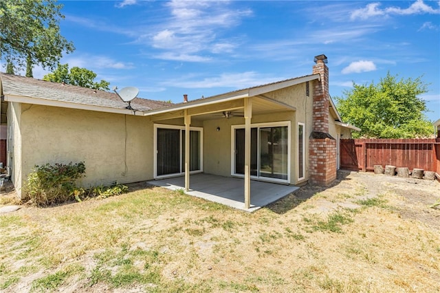 5712 Tupelo Dr, Sacramento, CA 95842 - back of house featuring stucco siding, a patio, a ceiling fan, and a chimney