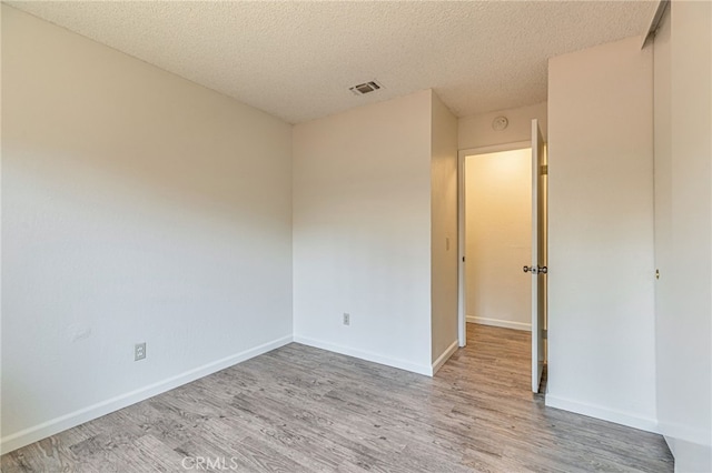 5712 Tupelo Dr, Sacramento, CA 95842 - spare room featuring light wood-style floors, a textured ceiling, and baseboards