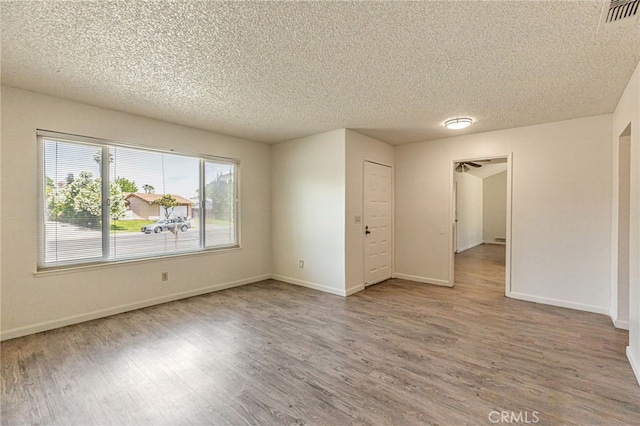 5712 Tupelo Dr, Sacramento, CA 95842 - unfurnished room featuring wood finished floors, a textured ceiling, and baseboards