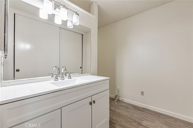 5712 Tupelo Dr, Sacramento, CA 95842 - bathroom with wood finished floors, vanity, baseboards, and a textured ceiling