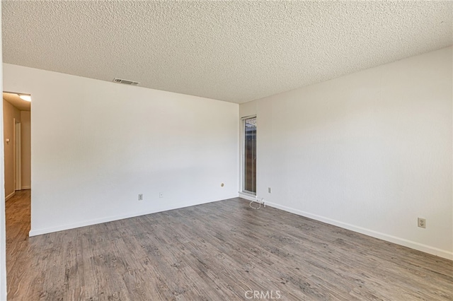 5712 Tupelo Dr, Sacramento, CA 95842 - unfurnished room with wood finished floors, a textured ceiling, and baseboards