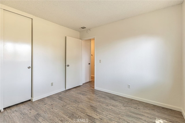 5712 Tupelo Dr, Sacramento, CA 95842 - unfurnished bedroom with light wood-type flooring, a textured ceiling, baseboards, and a closet