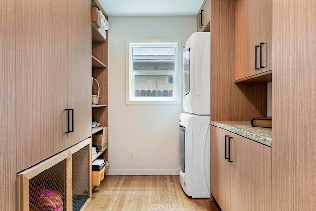 6320 E Los Santos Dr, Long Beach, CA 90815 - laundry area with stacked washer / dryer, cabinet space, light wood finished floors, and baseboards
