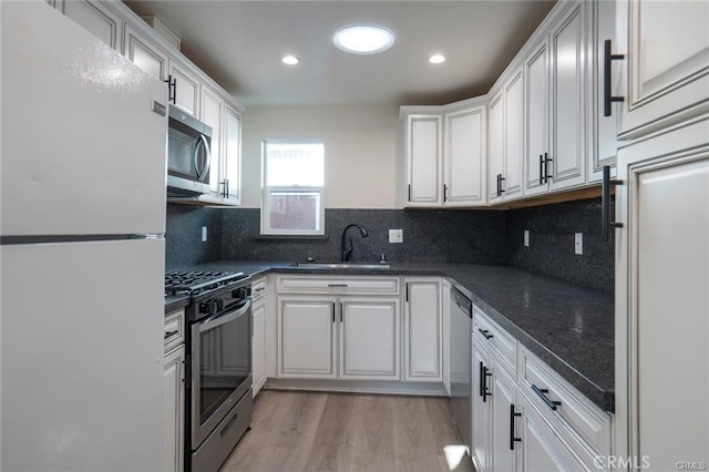 5919 Cantaloupe Ave, Valley Glen, CA 91401 - kitchen featuring stainless steel appliances, white cabinetry, light wood-type flooring, tasteful backsplash, and recessed lighting