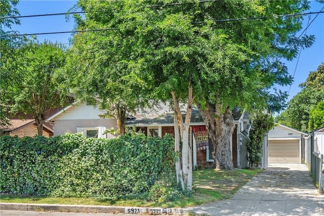 5919 Cantaloupe Ave, Valley Glen, CA 91401 - view of property hidden behind natural elements with an outdoor structure, concrete driveway, and a detached garage