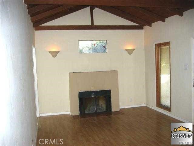 5919 Cantaloupe Ave, Valley Glen, CA 91401 - unfurnished living room featuring beamed ceiling, wood finished floors, high vaulted ceiling, and a fireplace with flush hearth