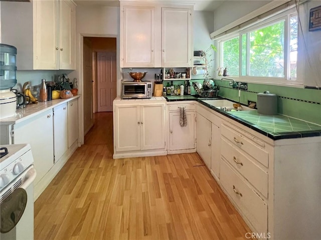 5919 Cantaloupe Ave, Valley Glen, CA 91401 - kitchen featuring white range with gas stovetop, white cabinetry, light wood-style floors, and tile countertops