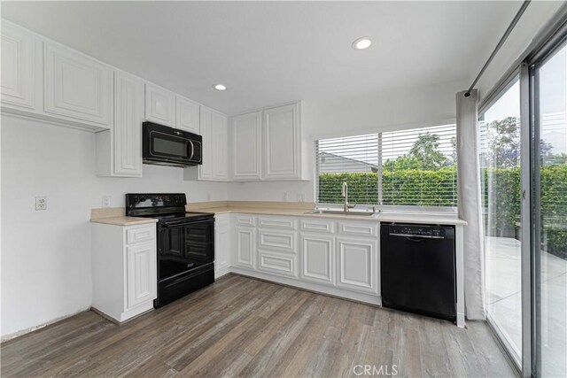 4252 Brookside St, Irvine, CA 92604 - kitchen featuring black appliances, a sink, light countertops, light wood-style flooring, and white cabinets