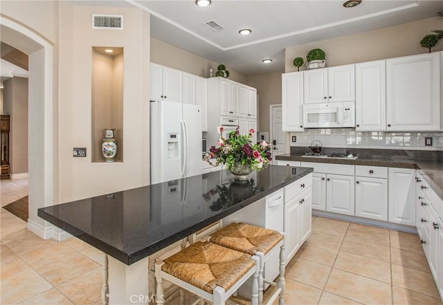 2012 Melbourne Cir, Banning, CA 92220 - kitchen with white appliances, light tile patterned flooring, arched walkways, and recessed lighting
