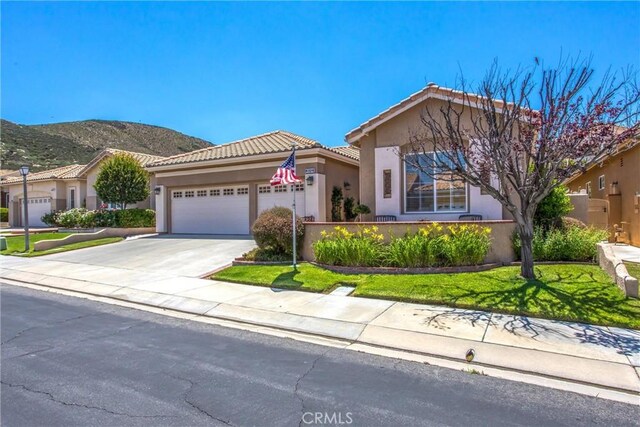 2012 Melbourne Cir, Banning, CA 92220 - view of front of home with a garage, stucco siding, concrete driveway, a tile roof, and a mountain view