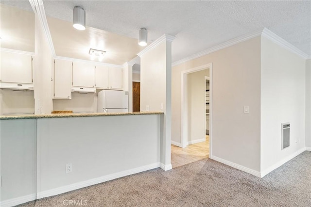 3605 W Hidden Ln Unit 112, Rolling Hills Estates, CA 90274 - kitchen featuring freestanding refrigerator, under cabinet range hood, light colored carpet, a textured ceiling, and ornamental molding