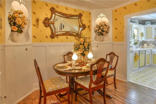 26335 Forest Ln, Twin Peaks, CA 92391 - dining room featuring ornamental molding, light wood-type flooring, a wainscoted wall, a decorative wall, and wallpapered walls