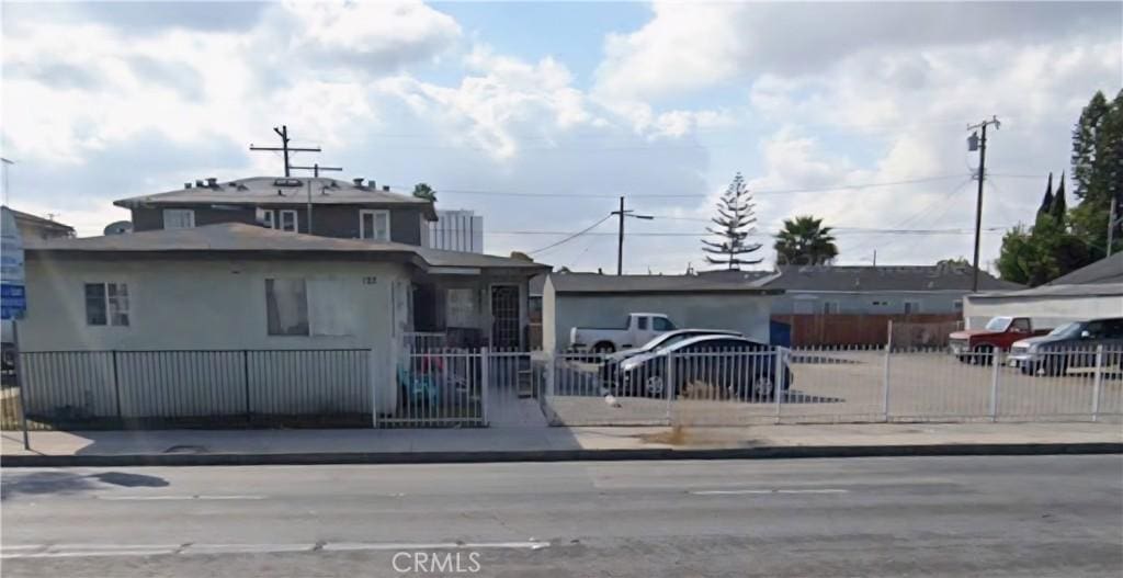 124 W Rosecrans Ave, Compton, CA 90222 - view of front of home with a fenced front yard and stucco siding