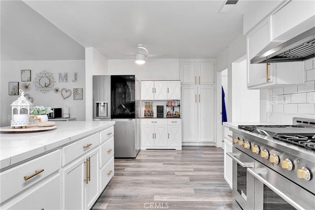 16229 Lake View Ln, Apple Valley, CA 92307 - kitchen with stainless steel appliances, wall chimney exhaust hood, light stone countertops, and white cabinets