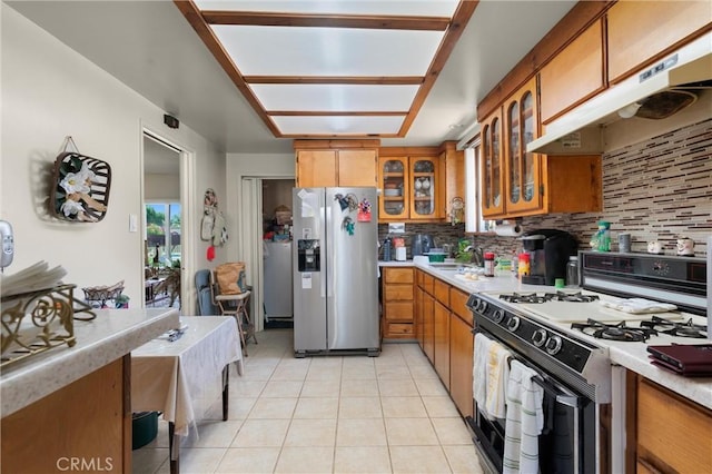 1601 163rd St W, Compton, CA 90220 - kitchen with white gas range, stainless steel refrigerator with ice dispenser, under cabinet range hood, and brown cabinets