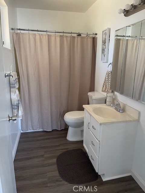 15577 Nisqualli Rd, Victorville, CA 92395 - full bath featuring vanity, wood finished floors, and a shower with shower curtain