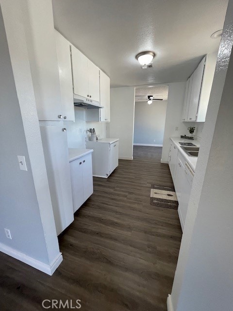 15577 Nisqualli Rd, Victorville, CA 92395 - kitchen featuring under cabinet range hood, a ceiling fan, dark wood-style flooring, white cabinets, and light countertops