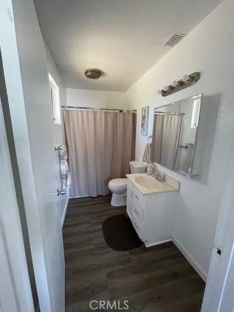 15577 Nisqualli Rd, Victorville, CA 92395 - full bathroom with wood finished floors, vanity, and a shower with curtain