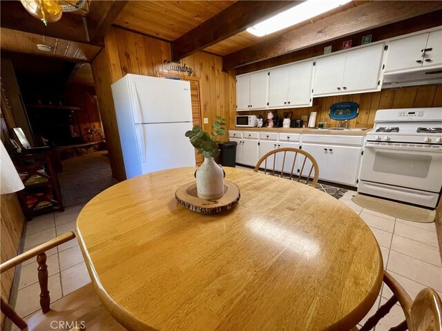 2076 8th Ln, Big Bear City, CA 92314 - dining room featuring wooden walls, wood ceiling with exposed beams, and light tile patterned floors