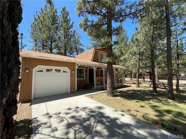 2076 8th Ln, Big Bear City, CA 92314 - view of front of property featuring driveway, an attached garage, a porch, and roof with shingles