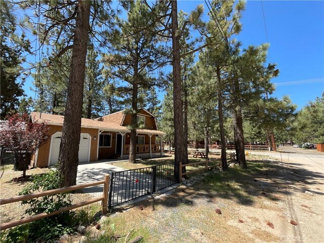 2076 8th Ln, Big Bear City, CA 92314 - view of front of property featuring a garage, a fenced front yard, covered porch, and concrete driveway