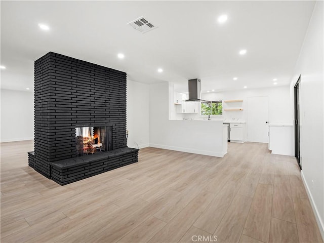 38537 Desert View Dr, Palmdale, CA 93551 - unfurnished living room featuring light wood-style floors, a brick fireplace, baseboards, recessed lighting, and a sink