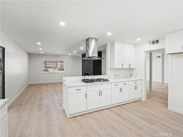 38537 Desert View Dr, Palmdale, CA 93551 - kitchen with island exhaust hood, stainless steel gas stovetop, light stone countertops, light wood-style floors, and recessed lighting