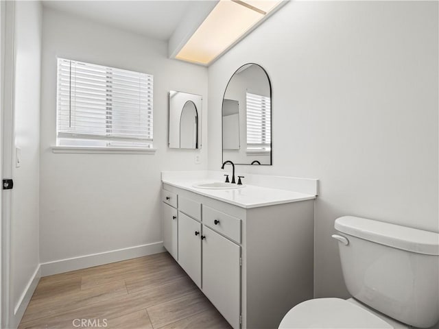 38537 Desert View Dr, Palmdale, CA 93551 - bathroom with vanity, toilet, wood finished floors, and baseboards