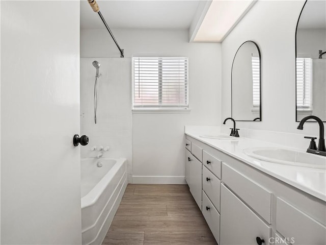 38537 Desert View Dr, Palmdale, CA 93551 - bathroom featuring bathing tub / shower combination, double vanity, wood finished floors, and baseboards
