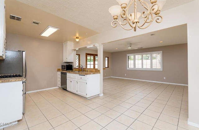 29421 Florabunda Rd, Canyon Country, CA 91387 - kitchen with stainless steel appliances, healthy amount of natural light, a chandelier, white cabinetry, and a textured ceiling