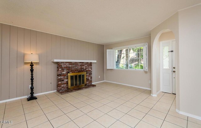 29421 Florabunda Rd, Canyon Country, CA 91387 - unfurnished living room featuring arched walkways, a fireplace, light tile patterned floors, and a textured ceiling