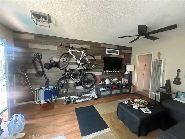 1101 E Ocean Blvd Unit 16, Long Beach, CA 90802 - exercise room with a heating unit, wood finished floors, ceiling fan, a textured ceiling, and wood walls