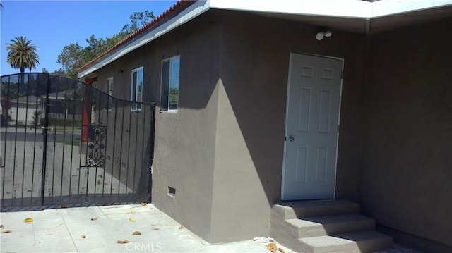 2420 Maine Ave, Long Beach, CA 90806 - view of exterior entry featuring stucco siding and a gate