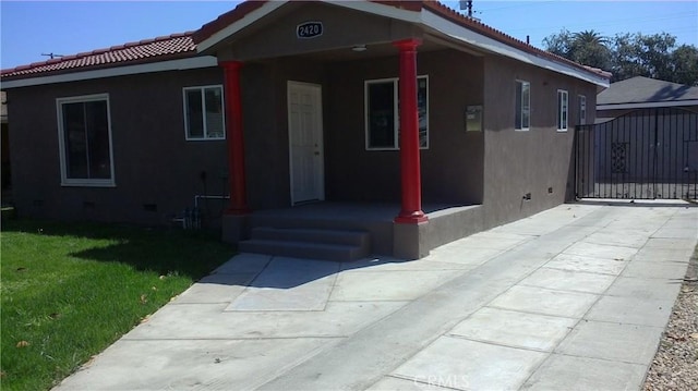2420 Maine Ave, Long Beach, CA 90806 - view of front of house with stucco siding, a front yard, a tiled roof, and a gate