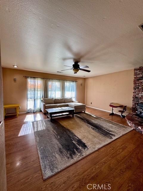 3646 Kirkwood Rd, Corning, CA 96021 - living room featuring wood finished floors, a textured ceiling, and ceiling fan